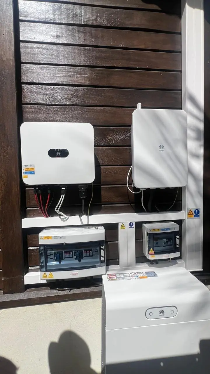 Onduleur Huawei, coffrets de protection et batterie de stockage Huawei installés sur un bardage en bois